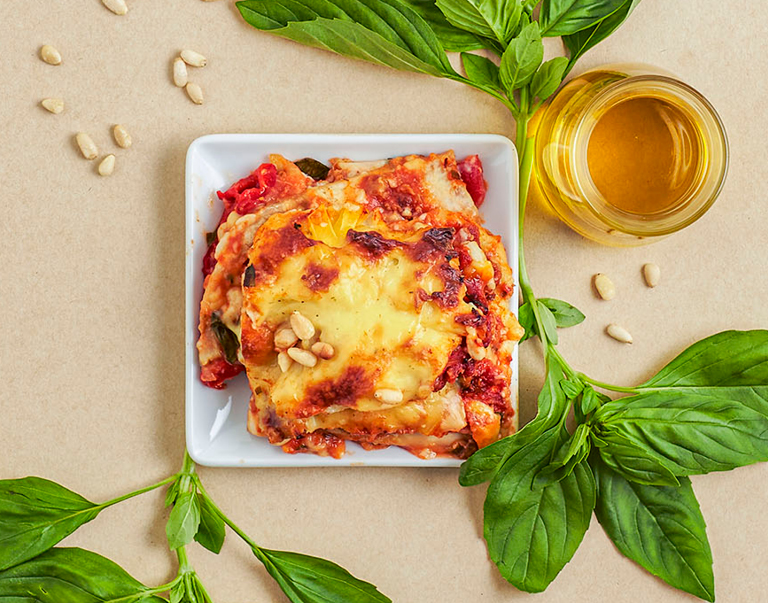 Deze klassiek ogende, smeuïge lasagne is gemaakt van dunne laagjes knolselderij en aubergine, afgewisseld met pulled oats, rijke tomatensaus en een veganistische ‘bechamel’ van amandelmelk.