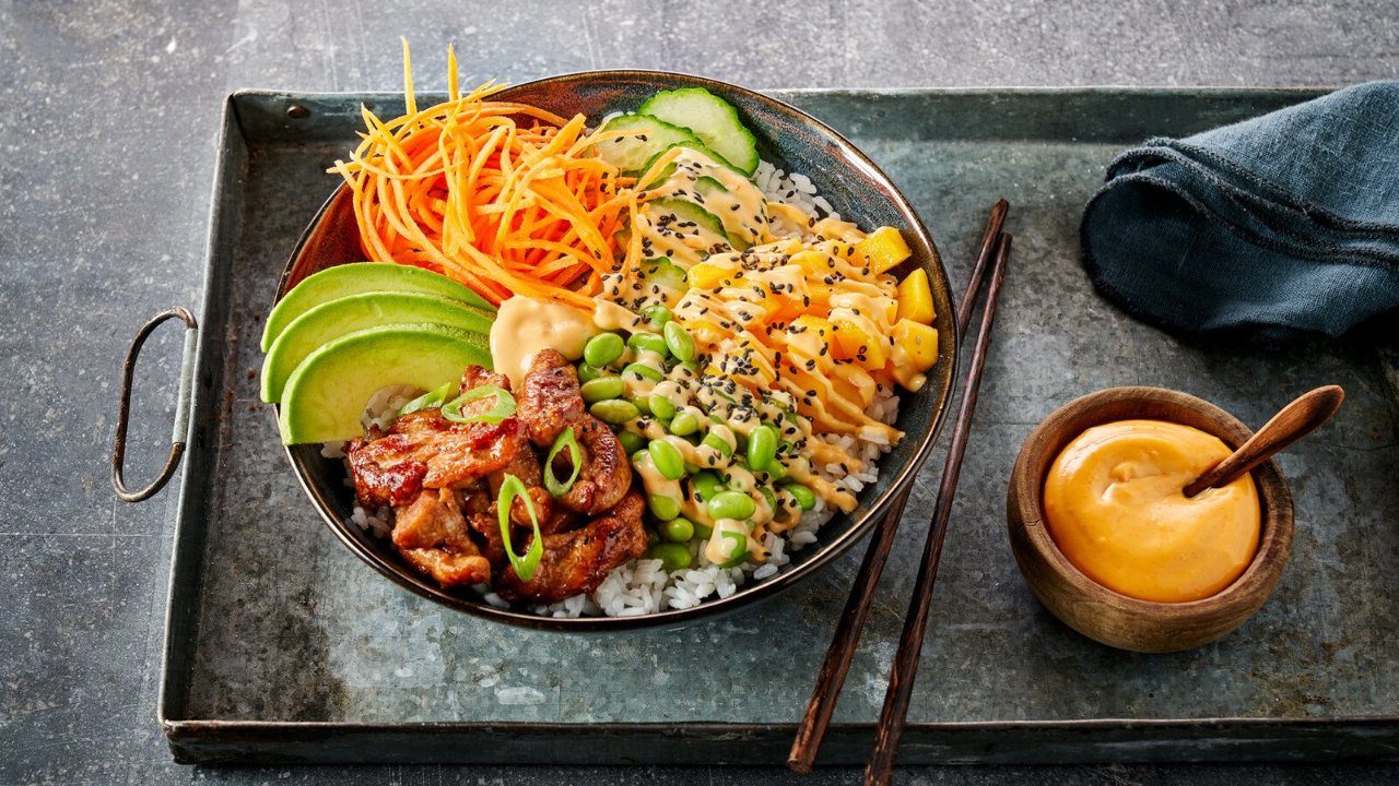 Deze poké bowl mag niet ontbreken op jouw menukaart. Heerlijk met kip, sushi rijst, edamame boontjes, avocado, mango, wortel en Garlic Sriracha Mayonaise.