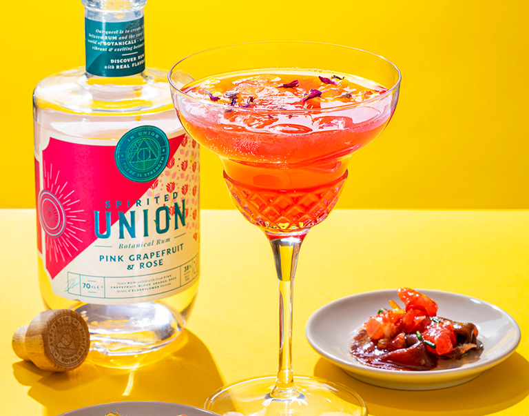 Deze cocktail op basis van rum met grapefruit, frambozensiroop en roze limonade heeft het allemaal: de smaak én de good looks.