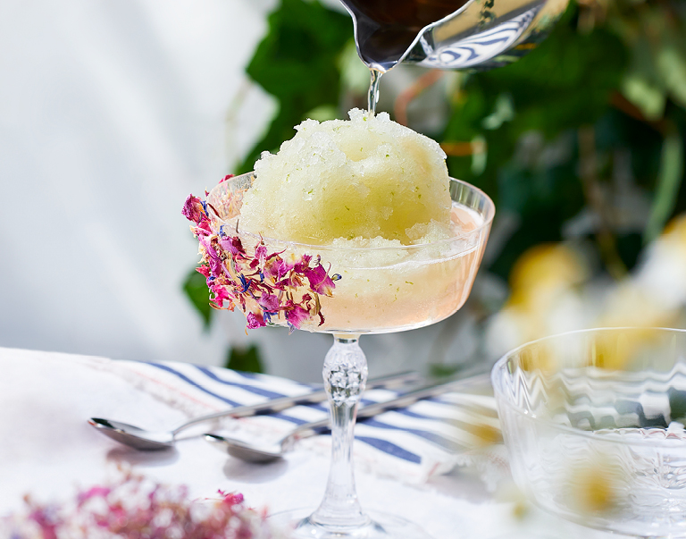 Cocktail van kokoswater, limoncello en gin met eetbare bloemetjes